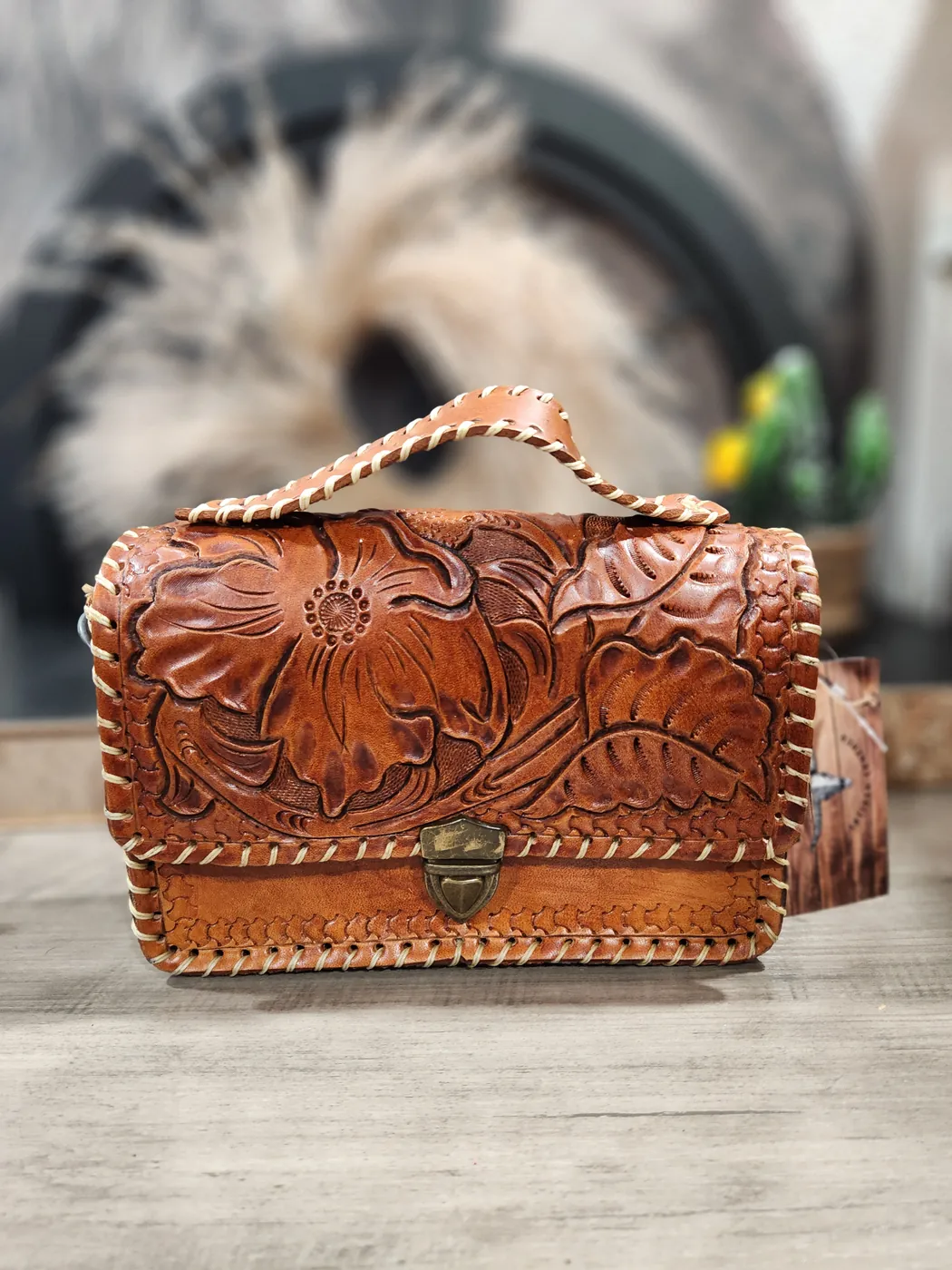 Hand-tooled floral satchel with whipstitched edges